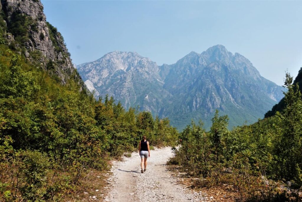 A hiker enjoying the stunning views from the Valbona Pass on the Theth to Valbona trail