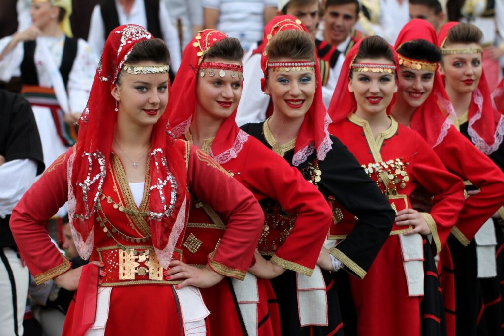 Traditional Albanian dancers in colorful costumes performing at a festival.