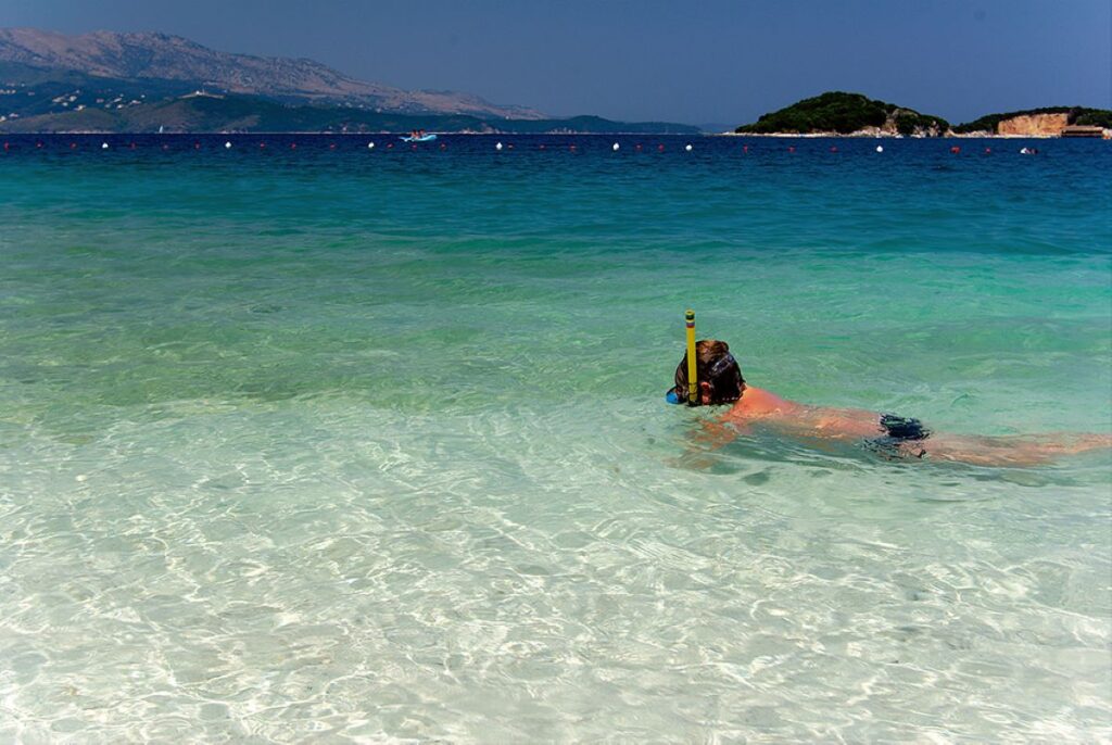 A family relaxing on the sandy shores of Ksamil Beach, enjoying Albania’s coastline.