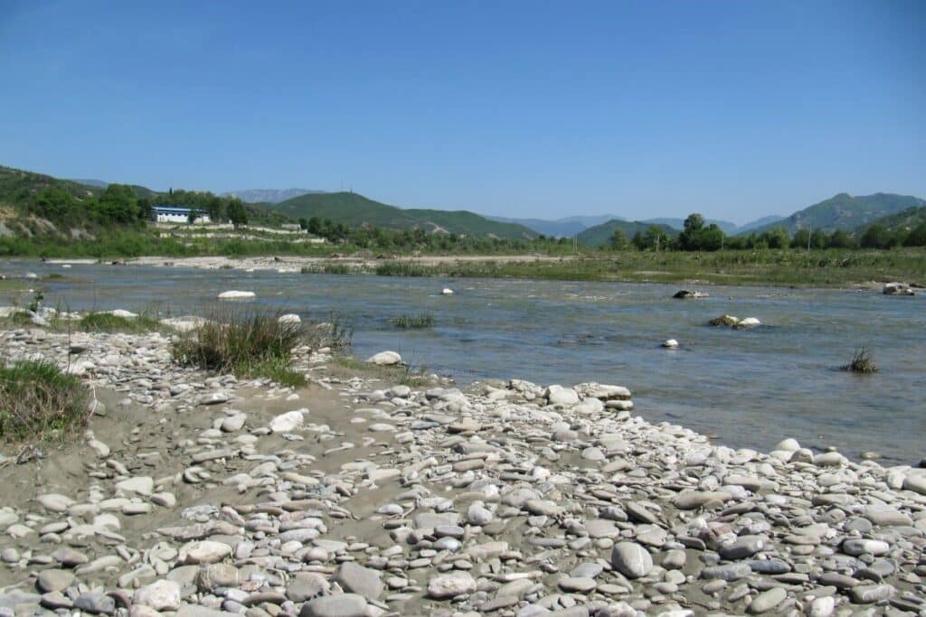 The Erzen River flowing through a picturesque canyon in Central Albania, surrounded by greenery.