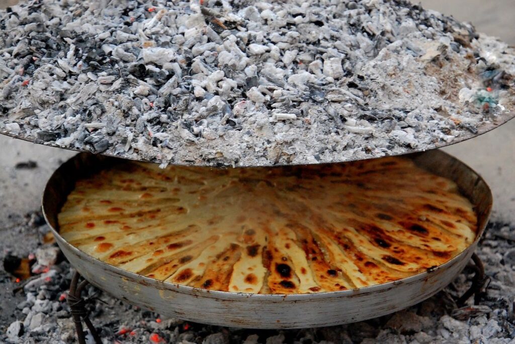 A table showcasing traditional North Albanian cuisine, including flija, trout, and raki.