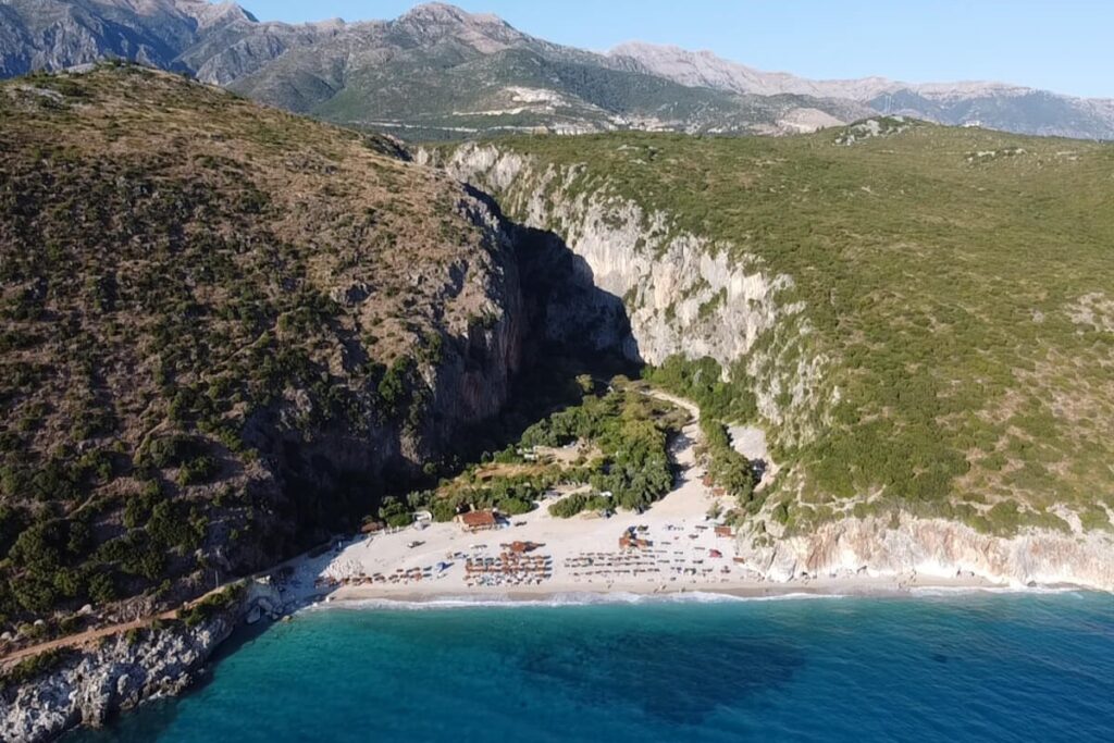 Gjipe Canyon’s towering cliffs leading to the pristine turquoise waters of Gjipe Beach in South Albania.