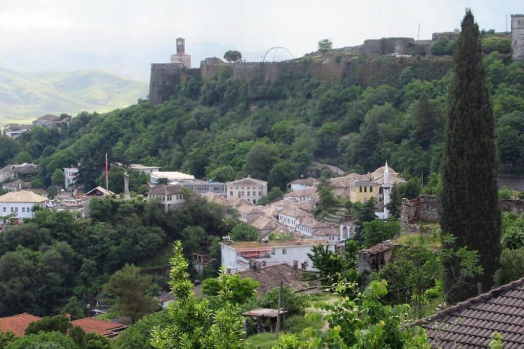 A panoramic view of Gjirokastër, featuring its stone rooftops and Gjirokastër Castle on the hill.