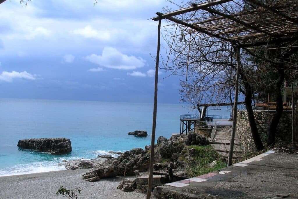 Himara Beach in South Albania at sunset, featuring golden sands and tranquil waters.