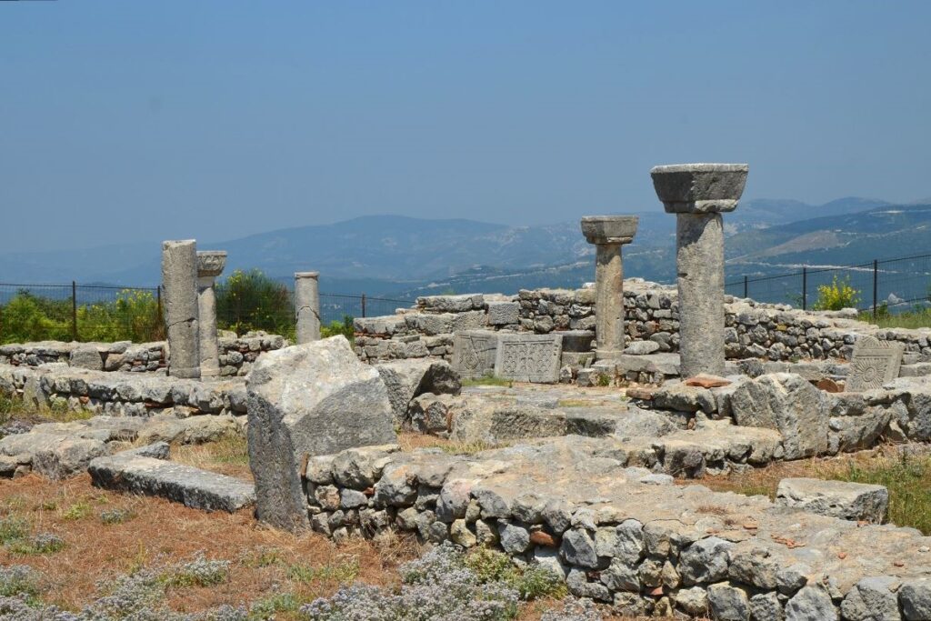 The ancient ruins of Byllis, Albania, showcasing its basilica and surrounding green landscapes.