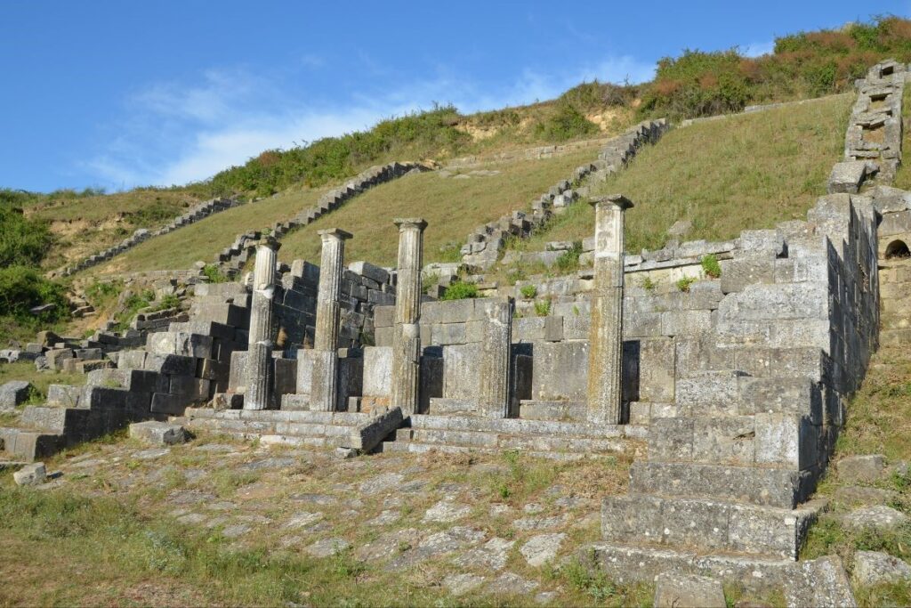 The ancient ruins of Apollonia in Albania, featuring the Monastery of St. Mary under a clear blue sky.