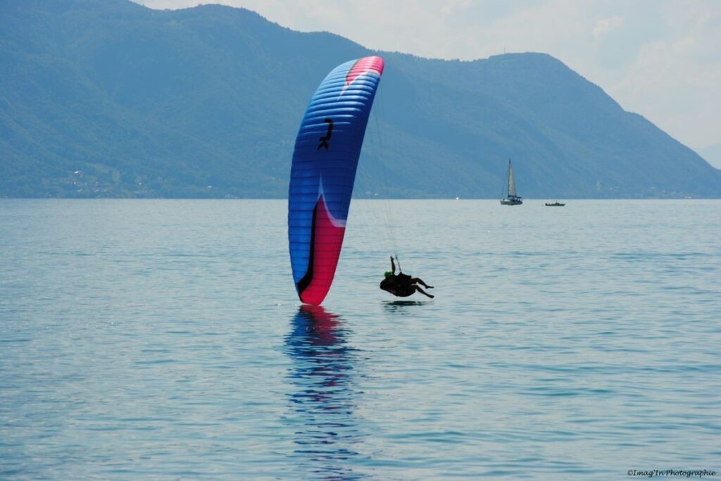 A paraglider flying over the stunning cliffs and turquoise waters of the Albanian Riviera in South Albania.