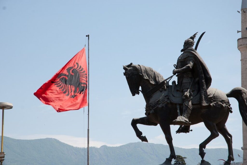 The red and black Albanian flag flying proudly over Skanderbeg Square on Independence Day.