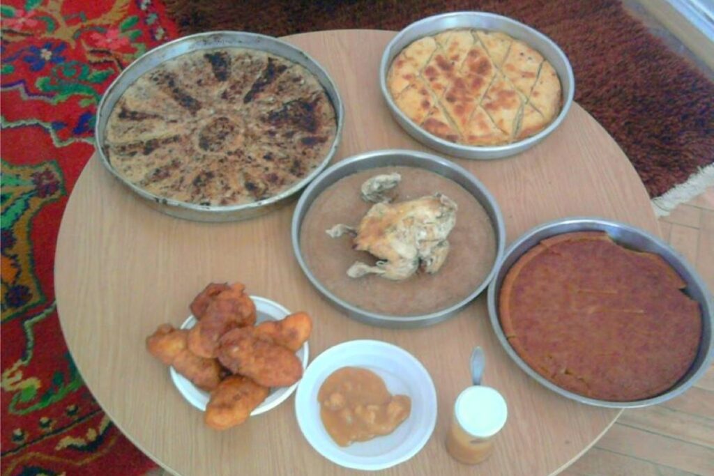 A table filled with traditional Northern Albanian dishes like flija, kacamak, and fresh mountain yogurt.