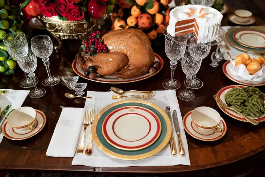 An Albanian Christmas table with roast turkey, bakllava, candles, and festive decorations.