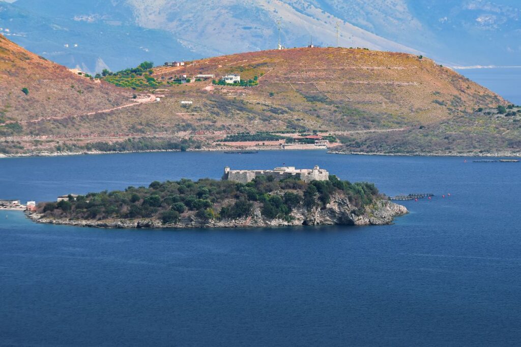 Porto Palermo Castle on a hill surrounded by the clear blue waters of Porto Palermo Bay in Albania.