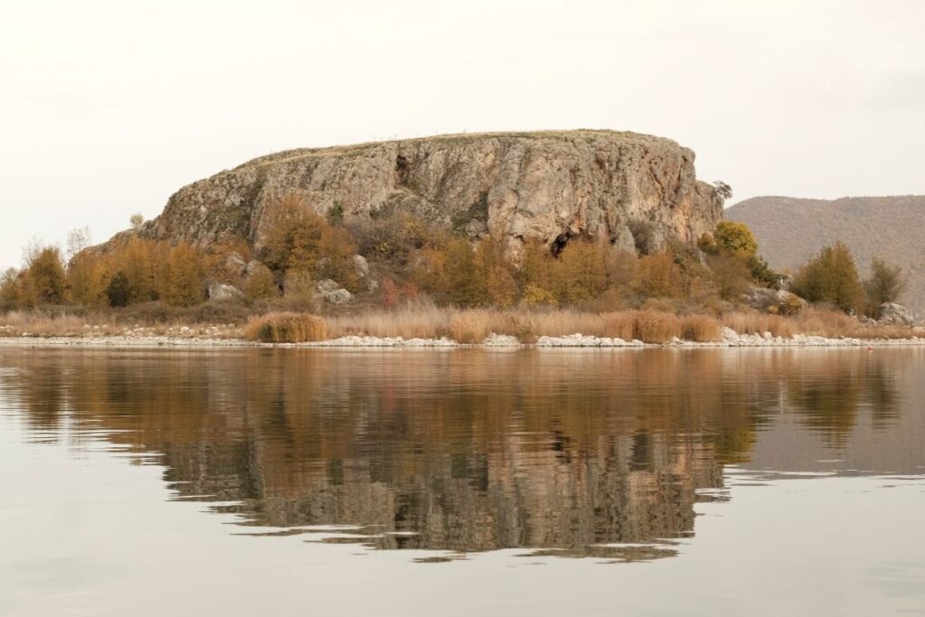 Great Prespa Lake with Maligrad Island surrounded by clear waters and mountainous landscapes.