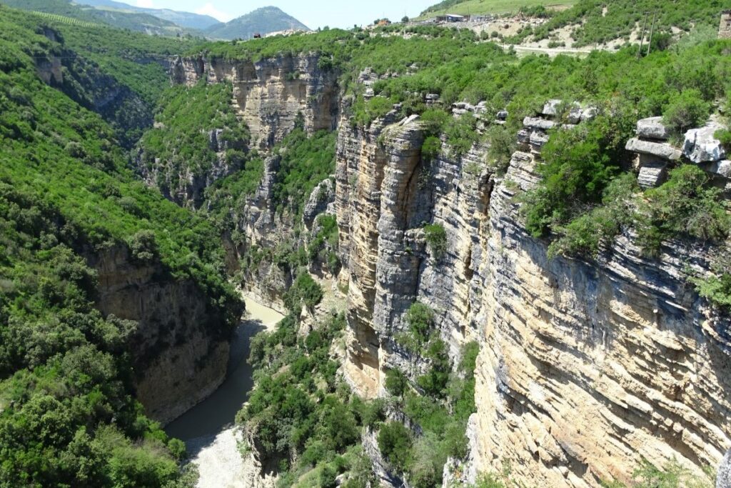 Osum Canyon with its towering cliffs and turquoise river winding below, offering a serene yet adventurous vibe.